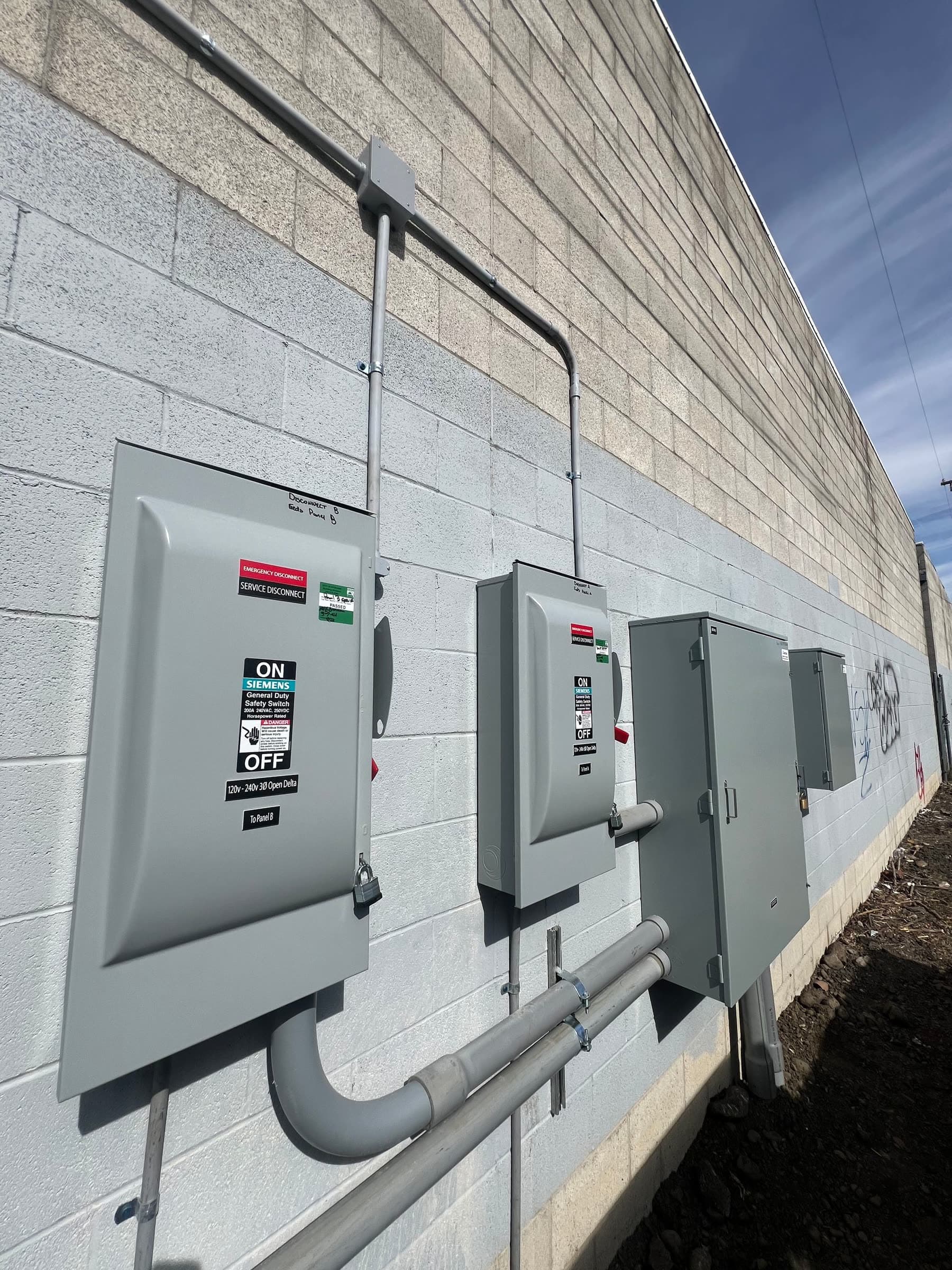 Commercial disconnect switches and conduit on a block wall