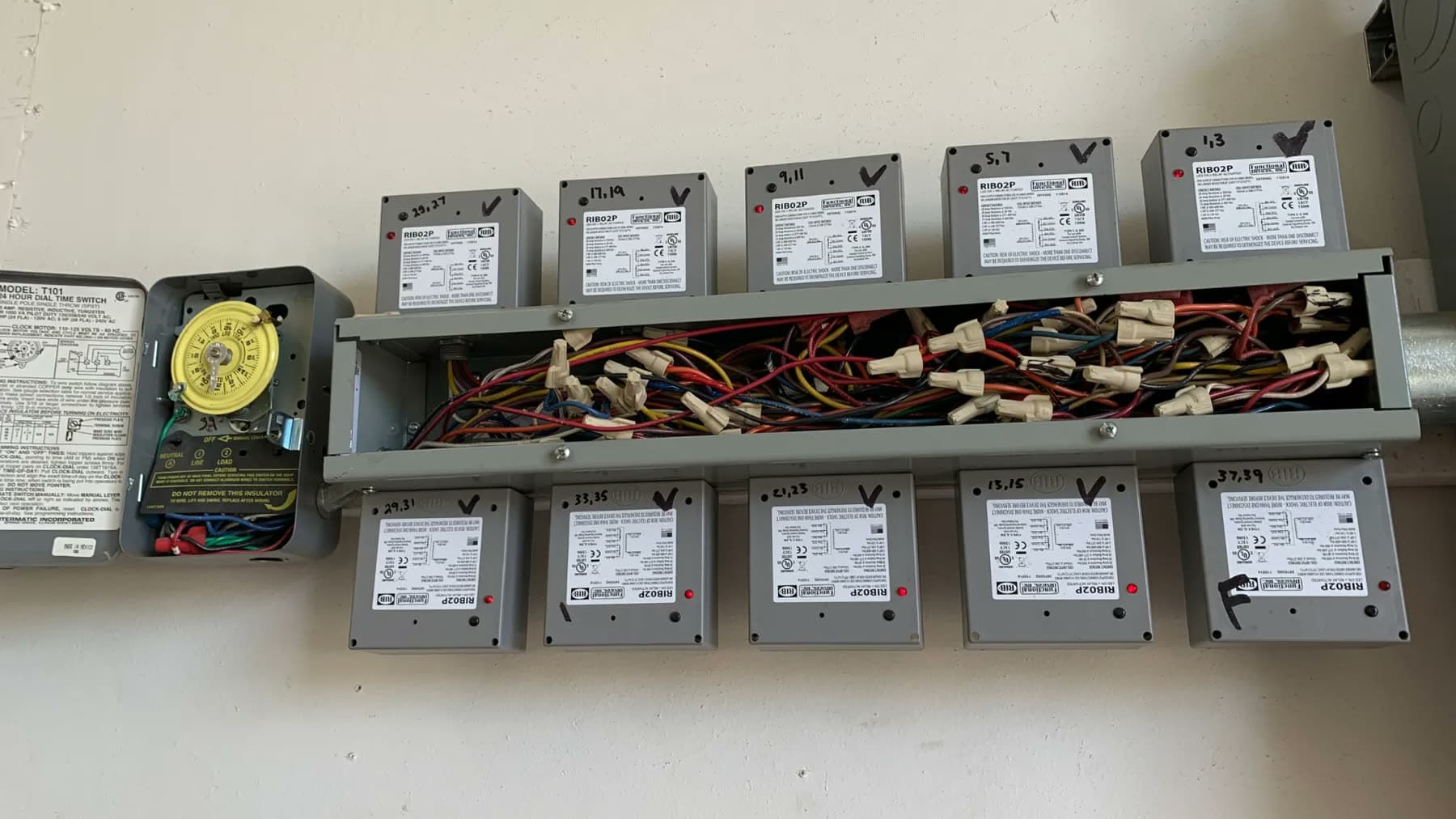Lighting control relays and timer in a wall-mounted enclosure