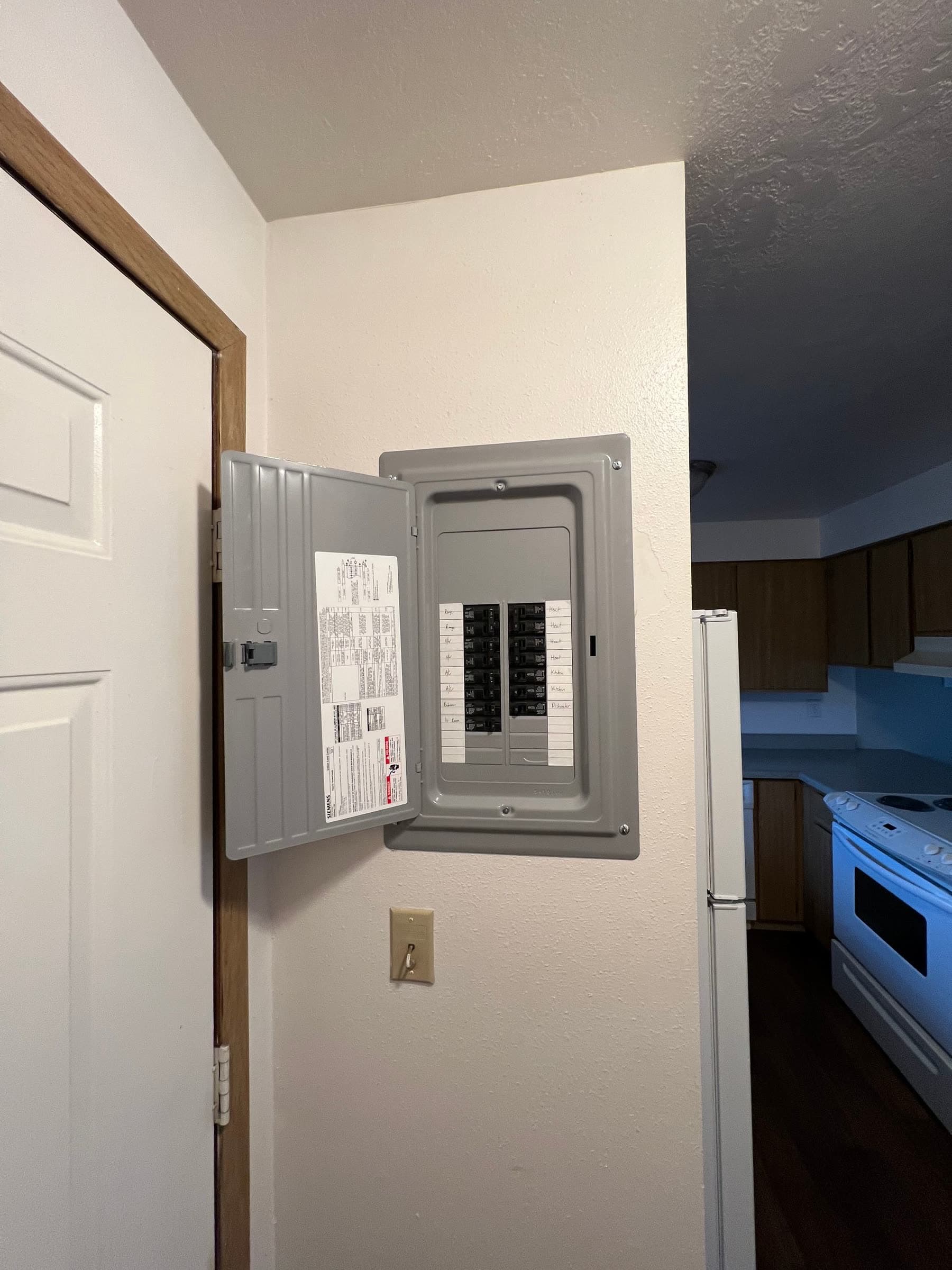 Residential electrical panel mounted in a home kitchen hallway