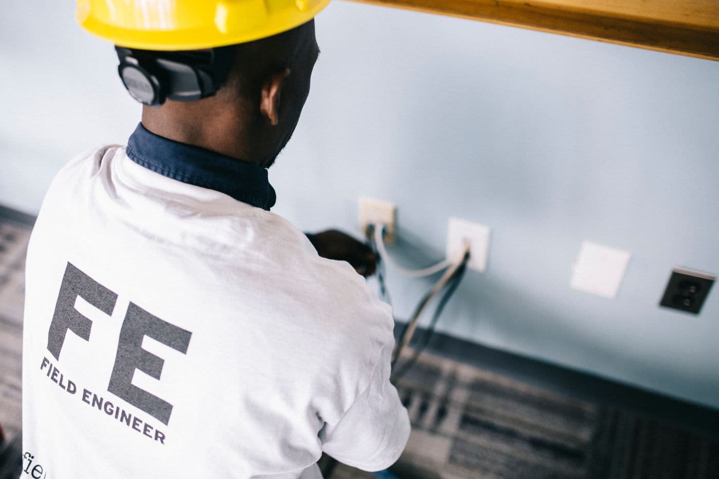 Electrician measuring voltage at a wall outlet